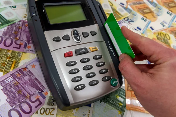 Human hand with credit card and terminal with euro banknotes — Stock Photo, Image