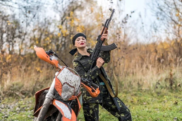 Mujer joven en ropa de camuflaje con pistola — Foto de Stock