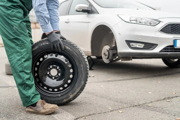 Arbeiter Hände mit Reserverad, Nahaufnahme — Stockfoto