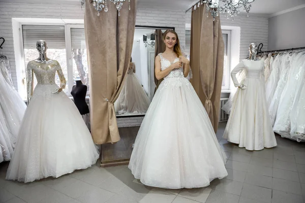 Bella giovane sposa in posa in abito da sposa in salone — Foto Stock