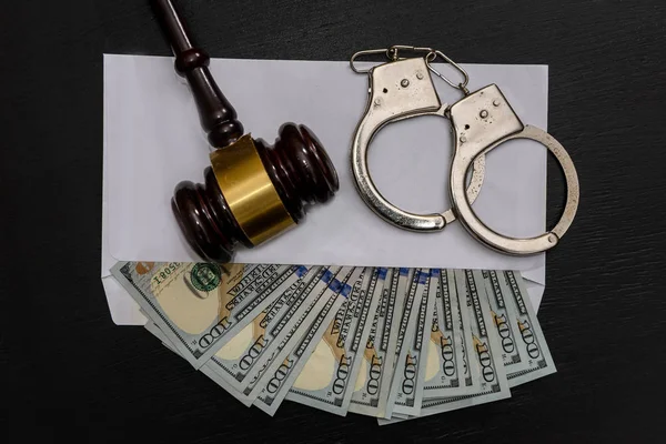 Dollars in envelope, handcuffs and judge's gavel — Stock Photo, Image