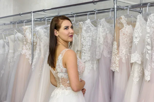 Gelinlikli güzel gelin butikte duruyor.