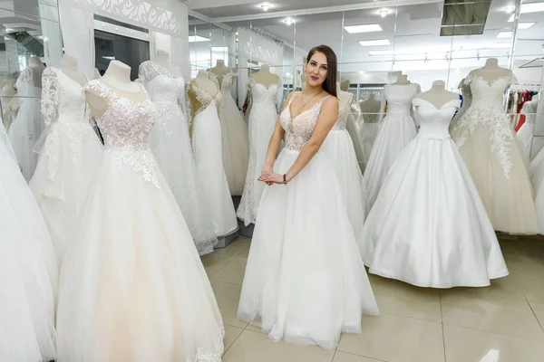 Молодая девушка примеряет красивое свадебное платье в магазине — стоковое фото