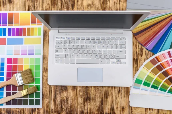 Laptop com amostras de cor na mesa de madeira para renovação de casa — Fotografia de Stock