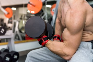 Spor salonunda dambılı erkek elleri yakın plan.