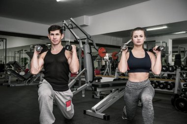 Erkek ve kadın spor salonunda çift olarak çalışıyor.