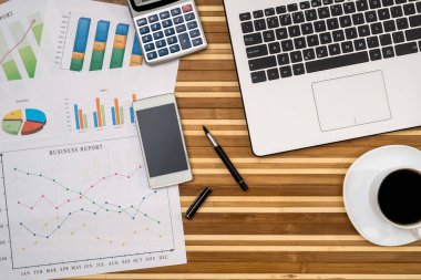 iş Çizelgeler ve grafikler ile laptop, fincan kahve, hesap makinesi ve kalem