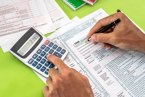 Mann Füllt Steuerformular Mit Stift Und Taschenrechner Aus — Stockfoto