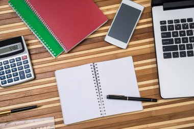Office tablo workspace dizüstü bilgisayar, not defteri, kalem, telefon ve hesap makinesi ile
