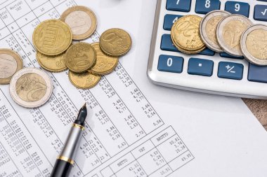 İş ve hesap makinesi, sikke, kalem ile finansal raporlar.