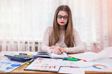 İş kadını ajandasında bir şeyler planlıyor, ofisinde çalışıyor.