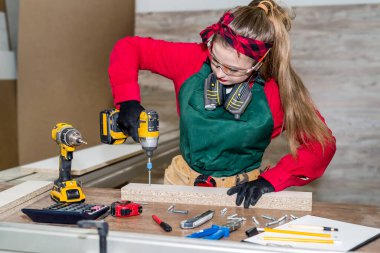 Marangozluk alanında mobilya yapan tornavidalı bir marangoz.