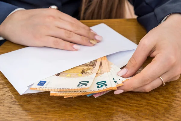 Avro banknotlarıyla zarfı açan kadın eller