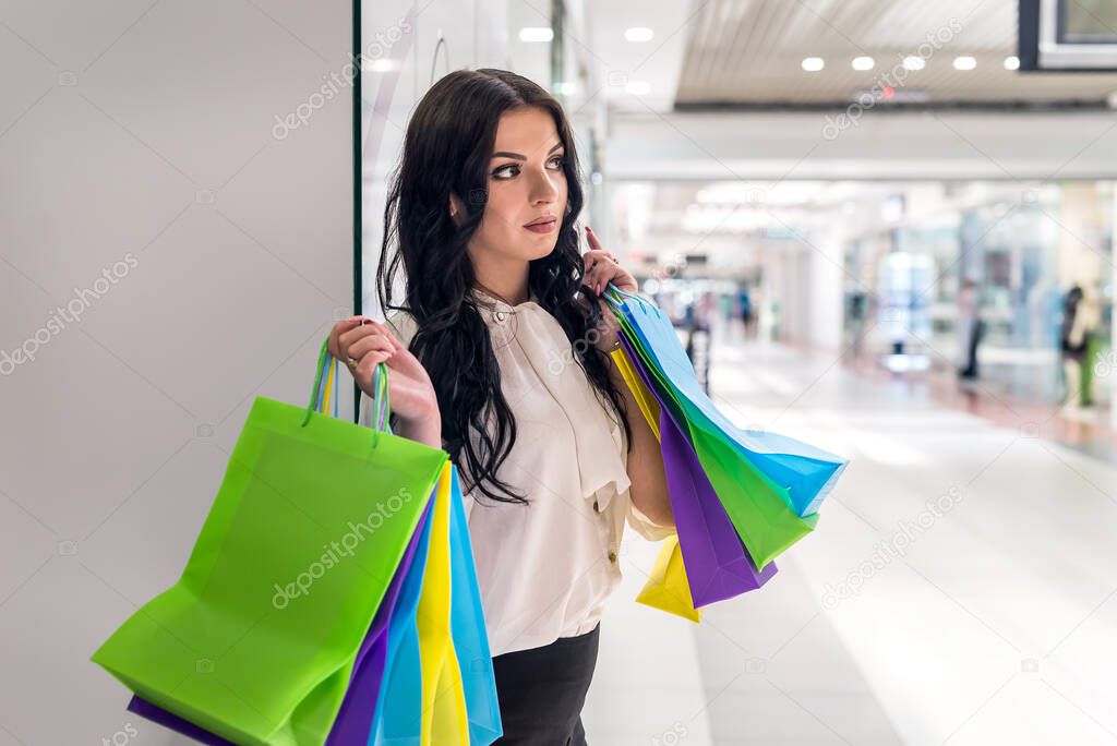 Woman with shopping bags little tired in mall