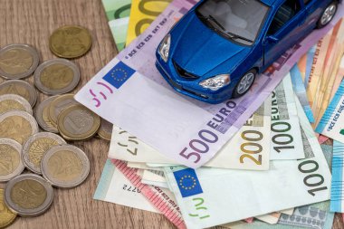Mavi oyuncak araba euro Bono ve madeni para ile.