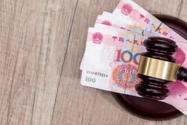 Masasında tahta çekiç olan Çin Yuan banknotu.