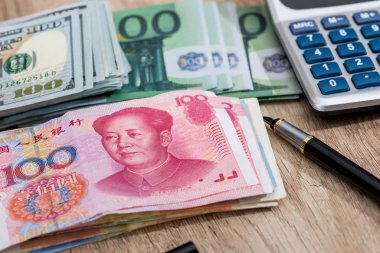 Hesap makinesi ile Euro, dolalr ve yuan kalem üstünde okul sırası ile.