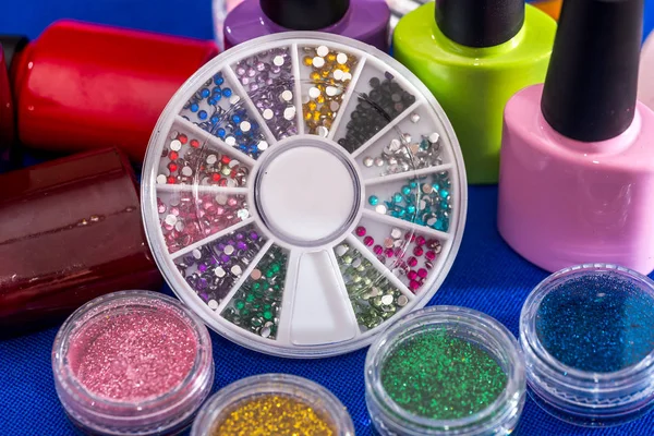 set of nail glitters and polish nail of different colors, close up.