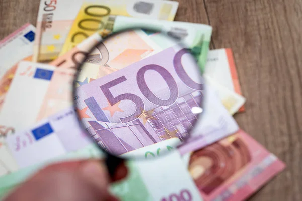 Büyüteç camı masa altında farklı Euro banknot.