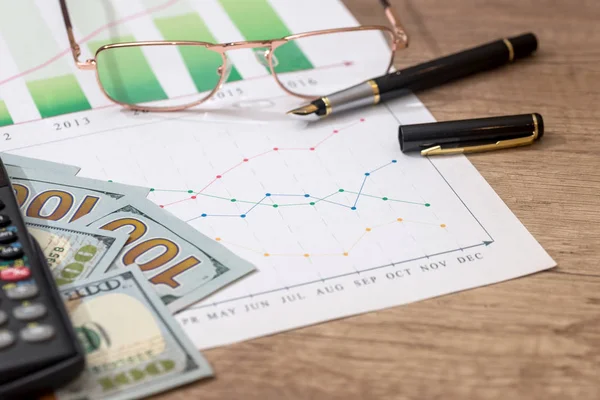 diagram with money, pen and calculator on table