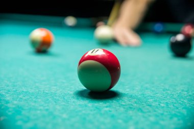 Karanlık kulüpte bilardo oynayan bir adam.