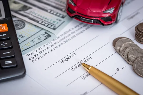 red toy car and money on signed contract of car sale