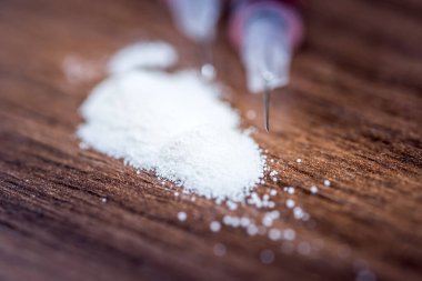 İlaç şırınga ve pişmiş eroin siyah arka plan üzerine izole.