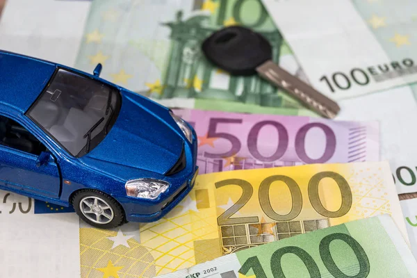 blue toy car and euro money coin and banknotes.