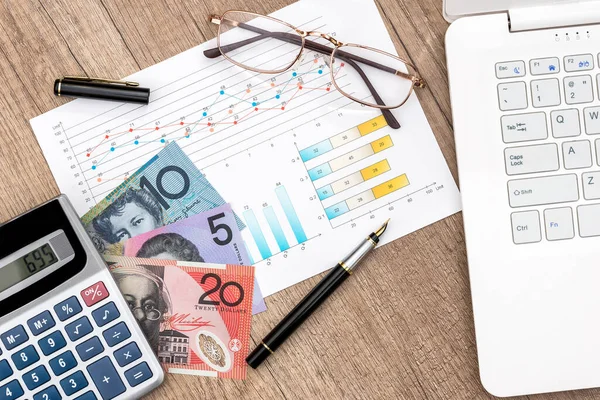 ラップトップの計算機と表のチャートを持つオーストラリアのお金 — ストック写真