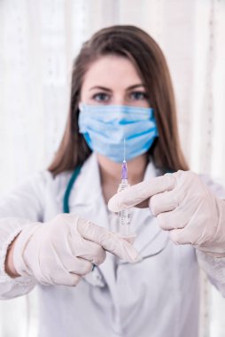 Doktor enjeksiyondan önce şırıngayı kontrol ediyor.