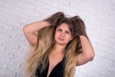 Long hair woman in studio on white brick wall background