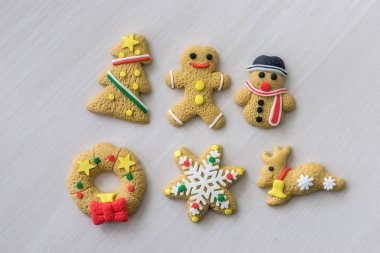 Arka plan olarak ahşap masada renkli noel kurabiyeleri