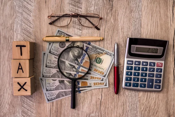 Holzwürfel Mit Dollarnoten Und Taschenrechner Auf Dem Schreibtisch — Stockfoto