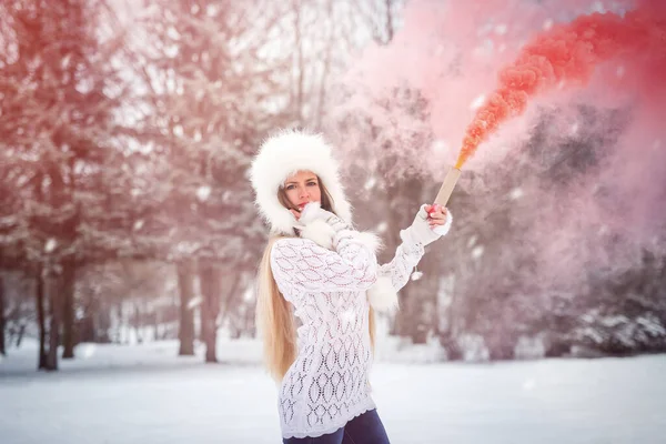 冬の公園で赤い煙爆弾を持つ女性 — ストック写真