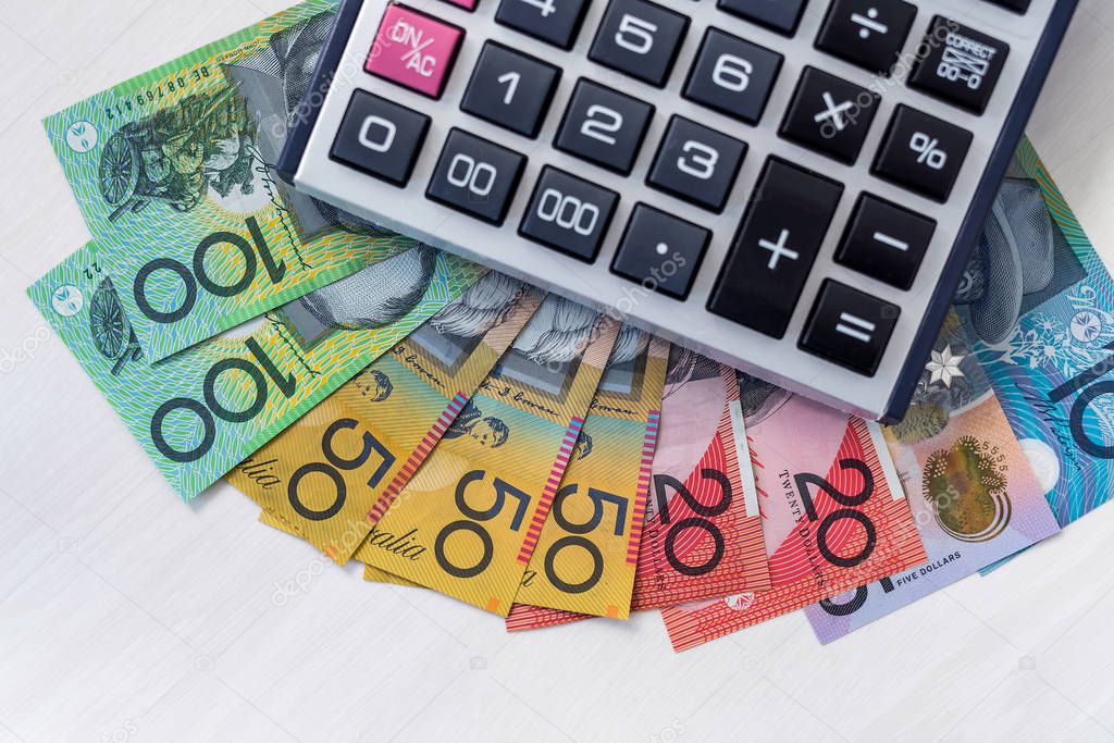 Calculator with colorful australian dollars on wooden table