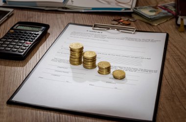 Kalem ve sözleşme kağıtları, hesap makinesi, ahşap masa üzerinde para