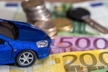 blue toy car and euro money coin and banknotes.
