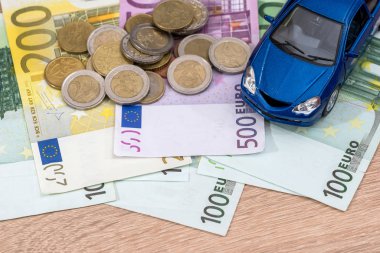 Mavi oyuncak araba euro Bono ve madeni para ile.