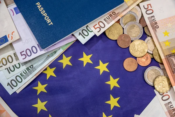 Euron räkningar med mynt, pass ovanför flagga — Stockfoto