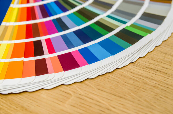 pantone color palette guide on wooden board close up view