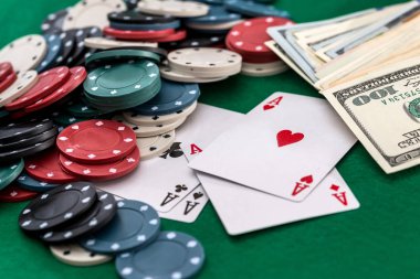 Yeşil arka planda poker fişleri, kartlar ve dolar