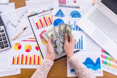 İş grafiklerinde doları olan kadın eller