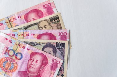 Çin Yuanı ve Japon Yen banknotları ahşap arka planda