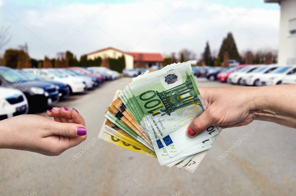 'Buying car' concept, hands with euro banknotes close up