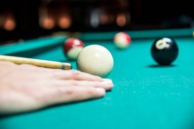 Karanlık kulüpte bilardo oynayan bir adam.