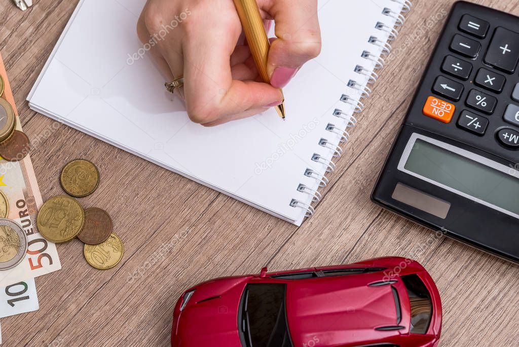 calculator with notepad, money and toy car