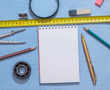 boş not defteri, kalem, cetvel ve grafik kağıt üzerinde pusula