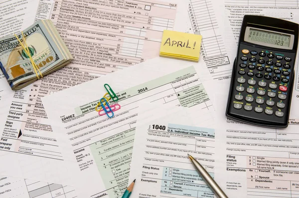 Federal Tax forms 1040 with pen, calculator and dollar