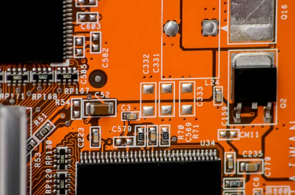 orange electronics computer part chip with many electrical components
