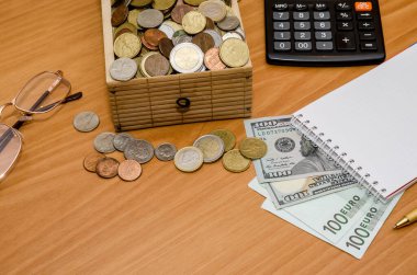 Hazine sandığı madeni para ile açın. Bize dolar ve euro boş not defteri, gözlük ve hesap makinesi